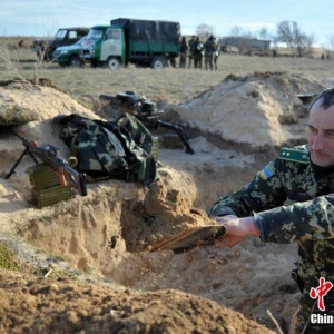 乌克兰士兵在边界附近挖战壕 装甲车在一旁警戒